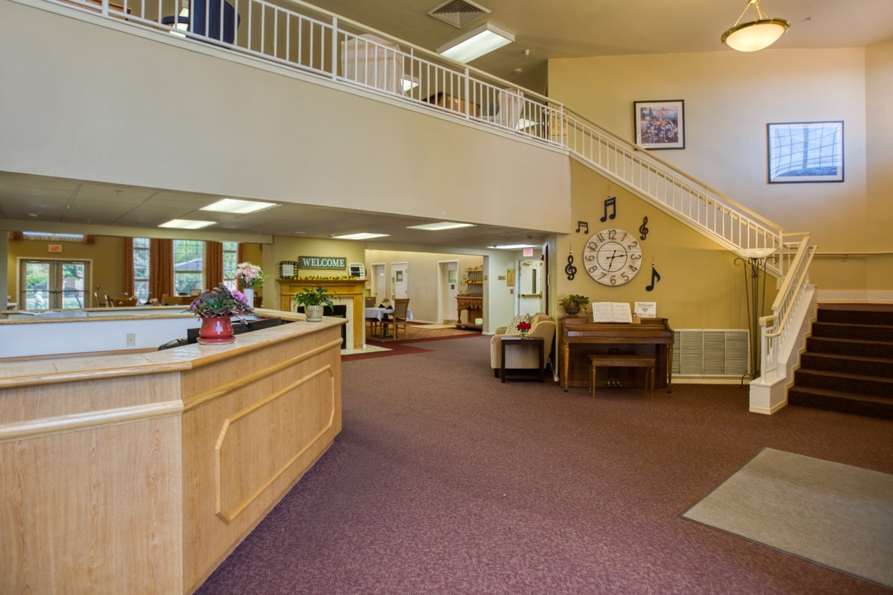 Interior image of Vista Pointe at Sierra Vista's lobby and entry way, showing a large staircase leading to a balcony upstairs.
