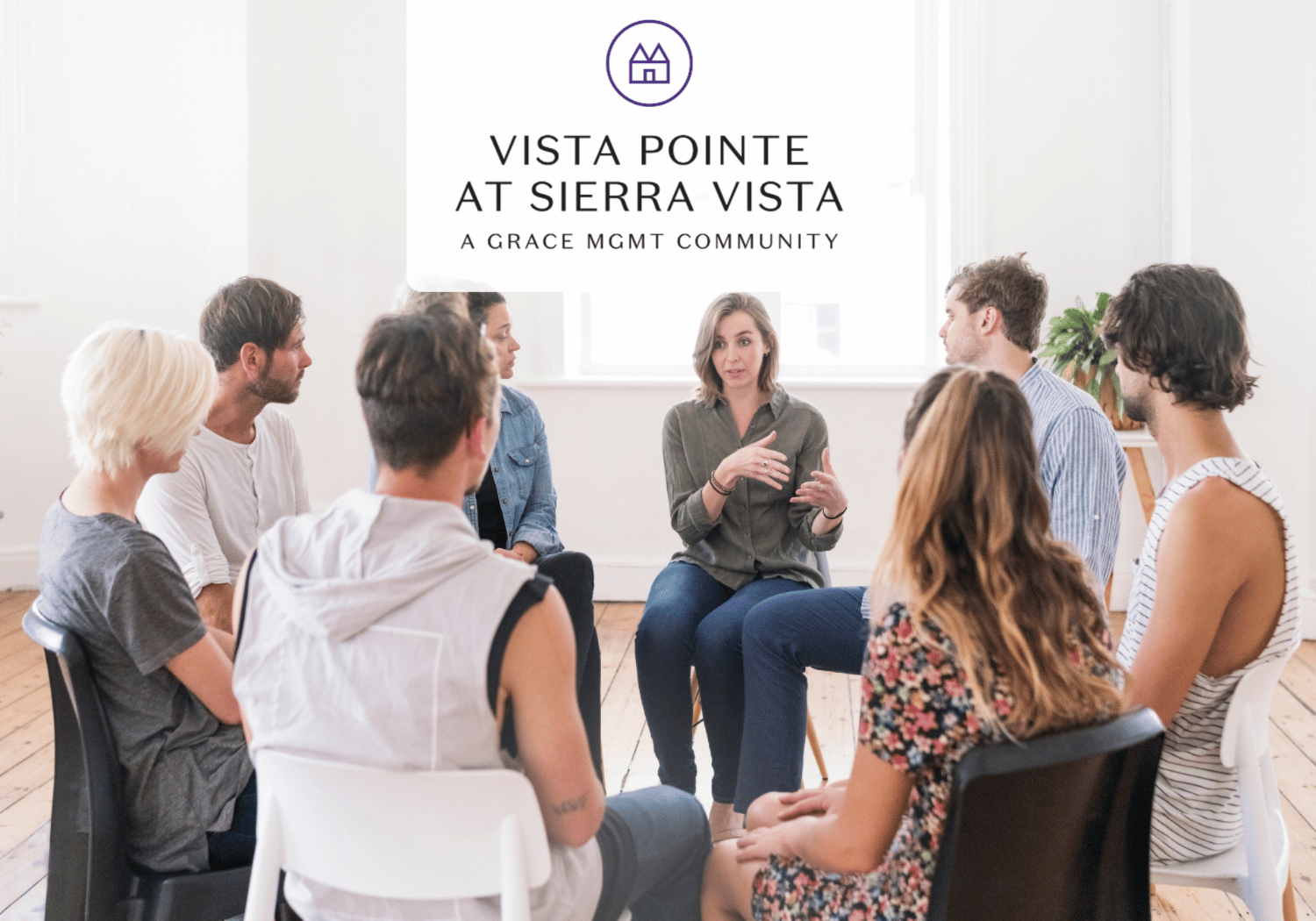 Eight people sit in a circle in a bright room as a woman speaks; the Vista Pointe at Sierra Vista logo appears above them.