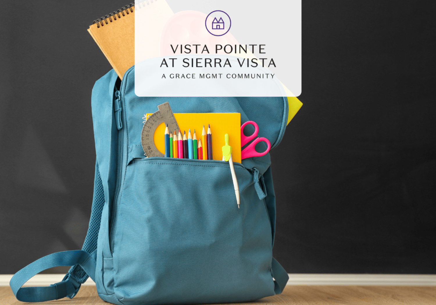 Blue backpack on a wooden floor with school supplies (pencils, ruler, scissors) peeking from the front pocket; overlay reads 'Vista Pointe at Sierra Vista, A Grace Mgmt Community'